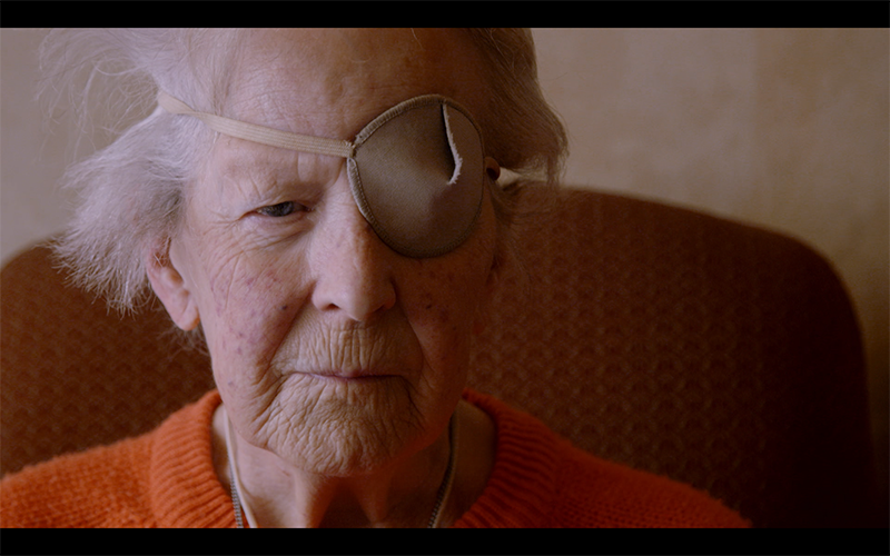 Still image from the Panorama Crisis in Care documentary.  A close up image of an old women with an eye patch over one of her eyes.