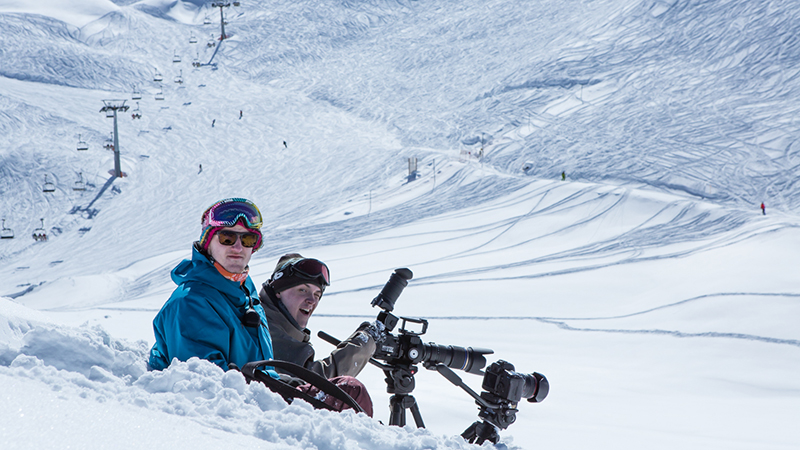 Ismar Badžić and George Simpson filming on a slope in a ski resort.